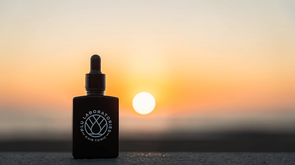 GKU-CU Hair Tonic next to the sunset
