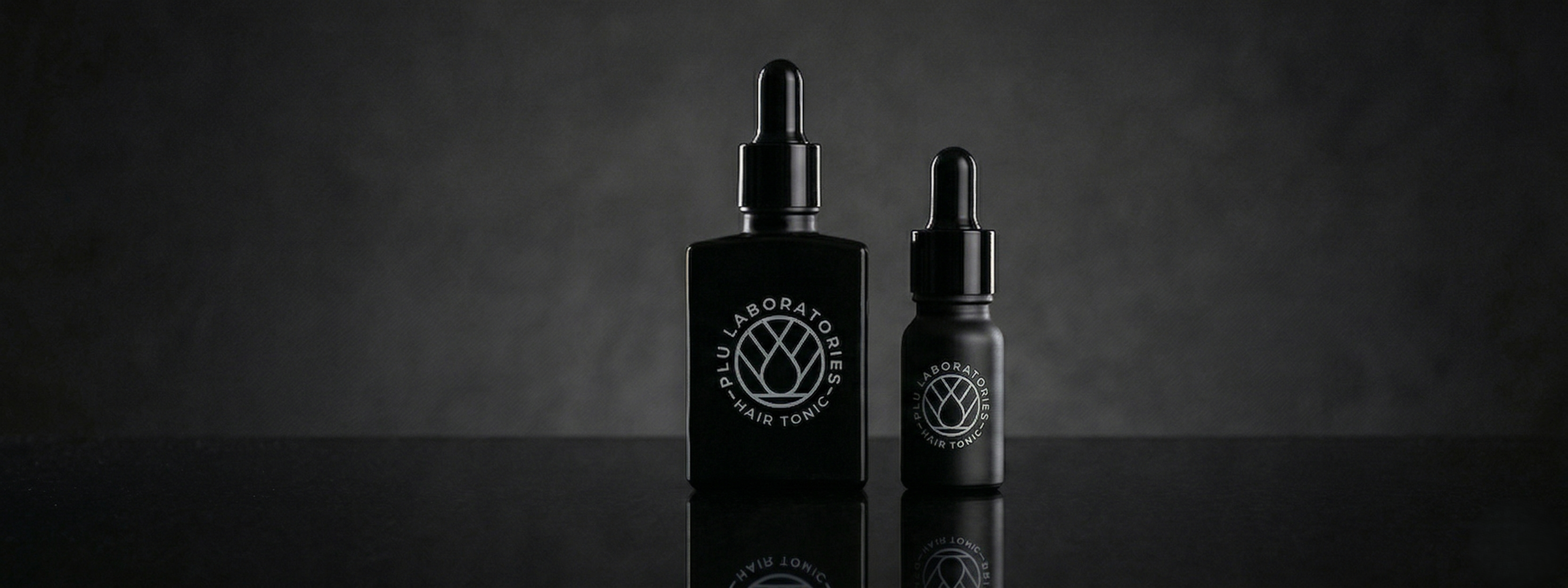 Two black bottles with droppers on a dark background