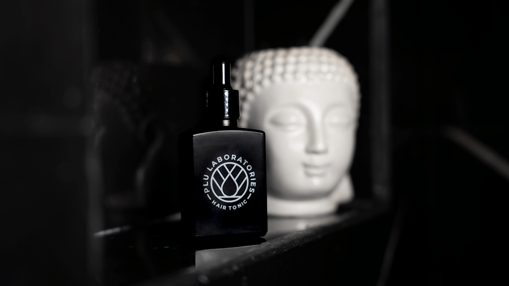 GHK-Cu Hair Tonic next to a statue