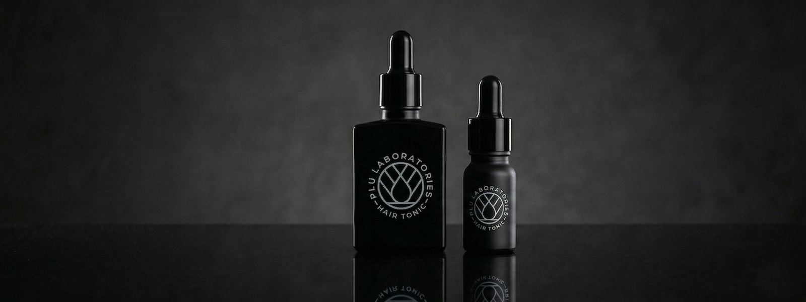 Two black bottles with droppers on a dark background