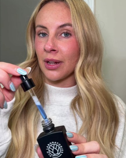 A customer holding the GHK-Cu Face Tonic with its dropper